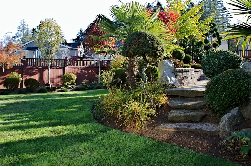 Backyard garden featuring natural stone steps, lush green grass, and topiary shrubs. Backyard garden featuring natural stone steps, lush green grass, and topiary shrubs.